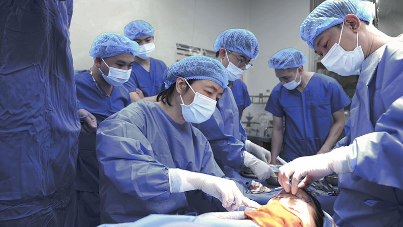 Dr. Richard Huy and the Kangnam Plastic Surgery team performing nasal reconstruction surgery for Lo Thi Le