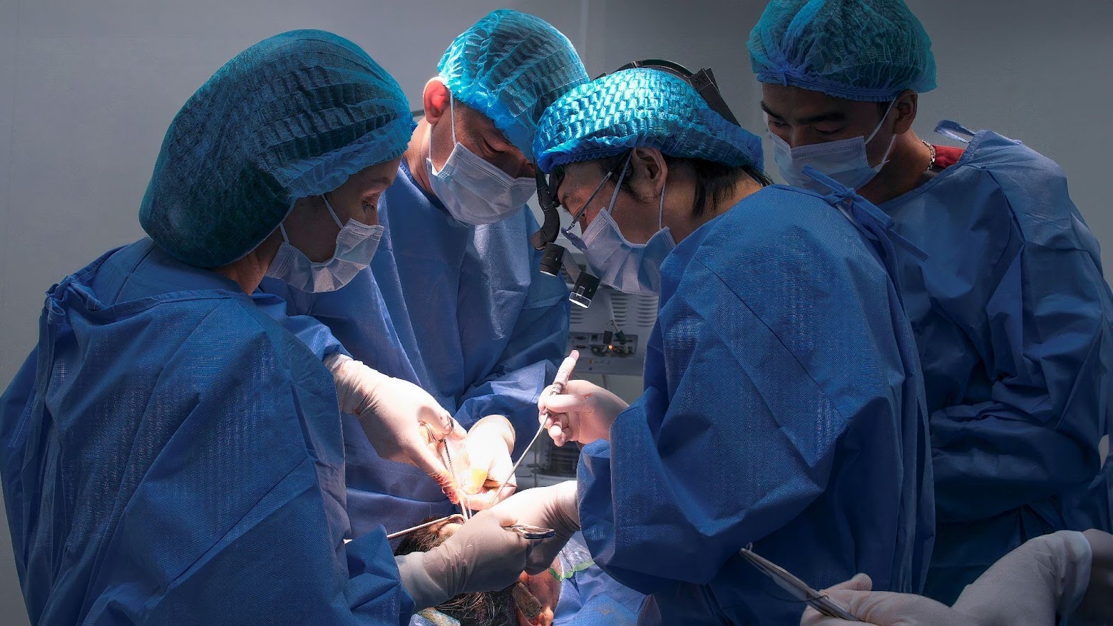 Doctor Richard Huy (wearing glasses) and the Surgical Team Performing Nasal Reconstruction for Lo Thi Le
