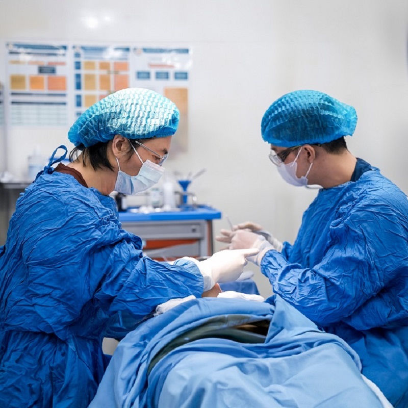 The surgical process is conducted in a closed, medically-standardized room.